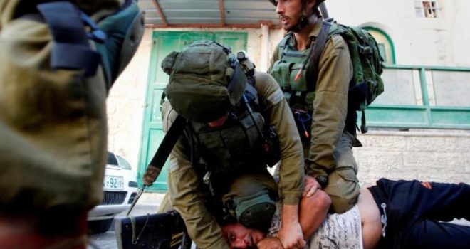 ionist forces assault Palestinian youth as he passes through military checkpoint near Deir Ballut